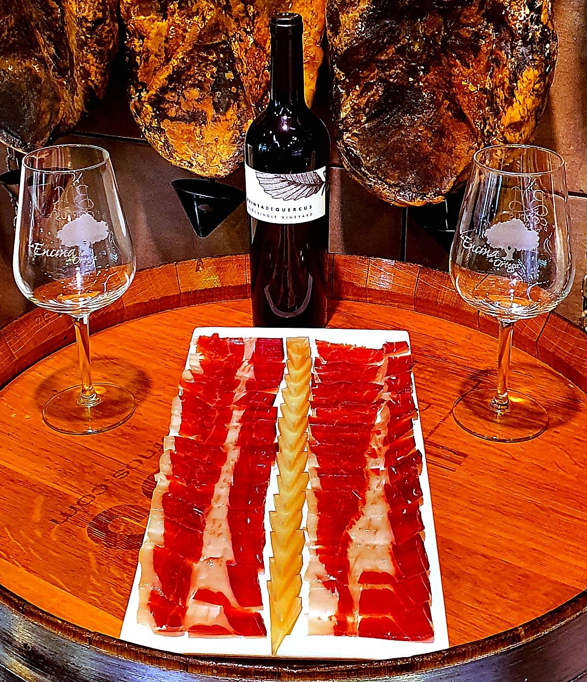 Board of acorn-fed Iberian ham and Manchego cheese on a barrel with two glasses of wine, Toledo